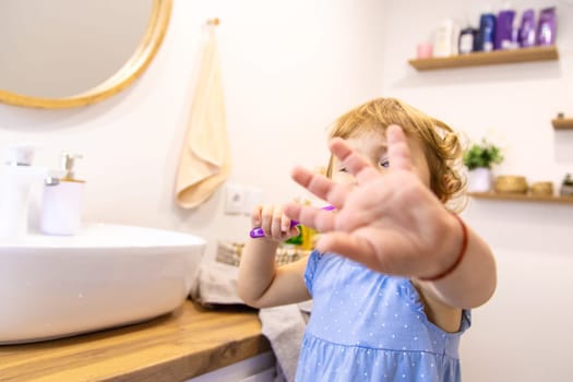 The child brushes his teeth in the bathroom. Selective focus. Nature.