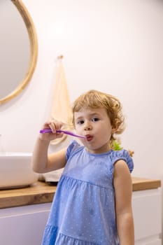 The child brushes his teeth in the bathroom. Selective focus. Nature.