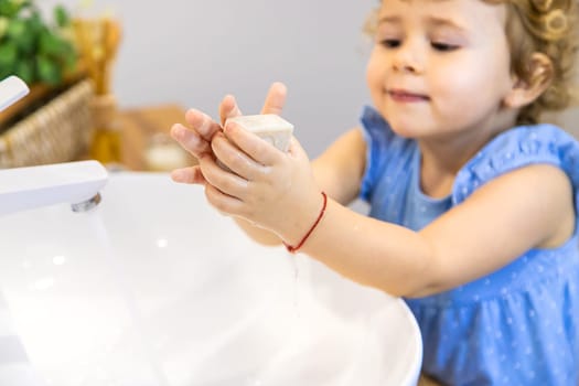 The child washes his hands with soap. Selective focus. Kid.