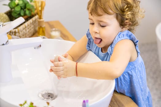 The child washes his hands with soap. Selective focus. Kid.