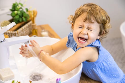 The child washes his hands with soap. Selective focus. Kid.