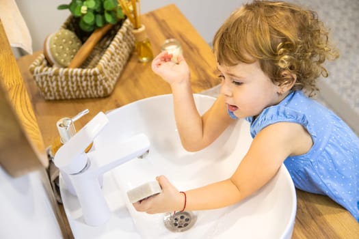 The child washes his hands with soap. Selective focus. Kid.