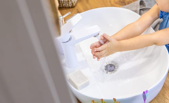 The child washes his hands with soap. Selective focus. Kid.