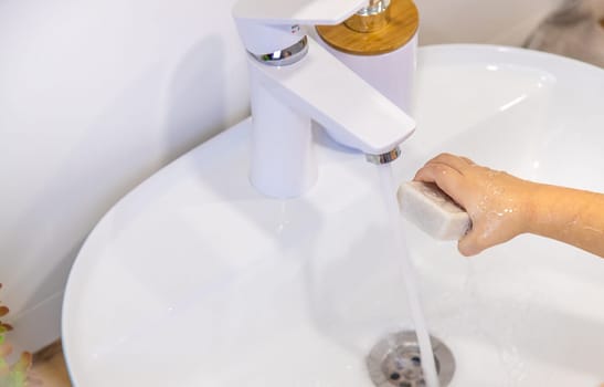 The child washes his hands with soap. Selective focus. Kid.