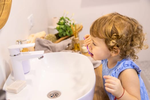 The child brushes his teeth in the bathroom. Selective focus. Nature.