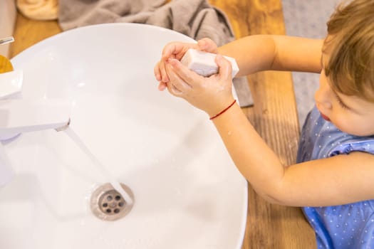The child washes his hands with soap. Selective focus. Kid.