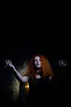 An evil red-haired witch holds fire in her hands