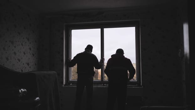 Silhouettes of workers installing new plastic windows