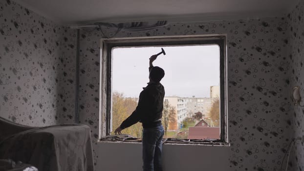 An employee removes an old wooden window