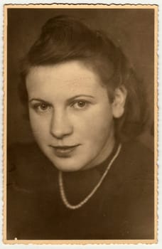OBERAMMERGAU, GERMANY - CIRCA 1940s: Vintage photo shows the portrait of a young girl. Retro black and white studio photography.