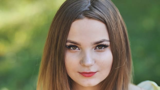 Portrait of a young girl in a park. Close-up of her face