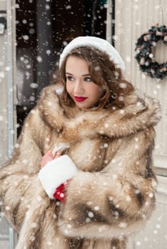 Young woman in fur coat with gift box at winter campsite getting ready for the new year.