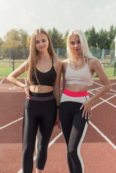 Two athlete young woman runnner at the stadium outdoors