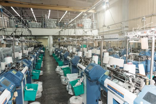 Interior of garment factory shop. Textile workshop with sewing machines, industry concept