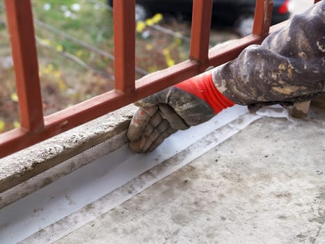 waterproofing the floor on the balcony with waterproofing tape close-up