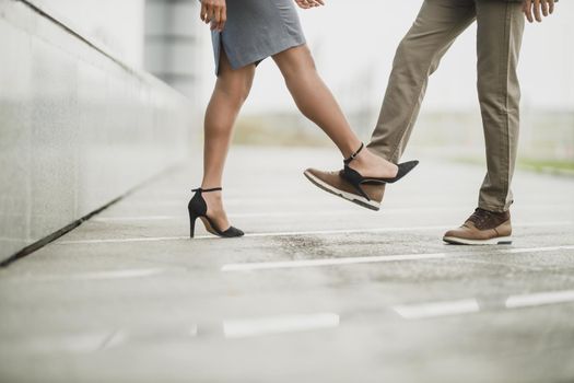 Cropped shot of an unrecognisable business people greeting with bumping feet outdoors during COVID-19 pandemic to avoid handshakes.