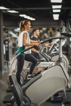 Shot of an attractive young woman exercising on the stepmill machines   at the gym.