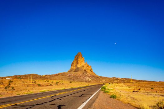 The rugged peaks of Agathla Peak (also known as El Capitan) towering over the desert landscape south of Monument Valley along Highway US Route 163 in northern Arizona, United States