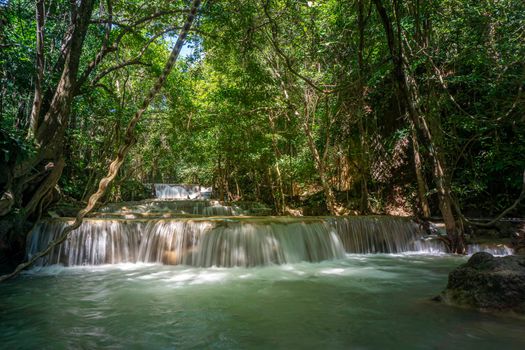 The clean waterfall there is an emerald green colour caused by reflections from trees and lichen circulating through the yellow limestone. Huai Mae Khamin Waterfall, Kanchanaburi Province
