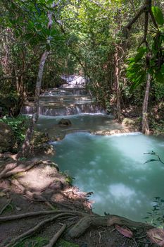 The clean waterfall there is an emerald green colour caused by reflections from trees and lichen circulating through the yellow limestone. Huai Mae Khamin Waterfall, Kanchanaburi Province