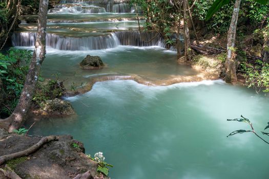 The clean waterfall there is an emerald green colour caused by reflections from trees and lichen circulating through the yellow limestone. Huai Mae Khamin Waterfall, Kanchanaburi Province