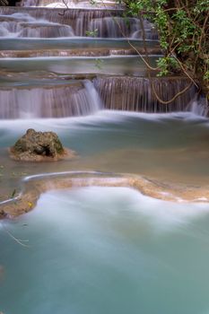 The clean waterfall there is an emerald green colour caused by reflections from trees and lichen circulating through the yellow limestone. Huai Mae Khamin Waterfall, Kanchanaburi Province