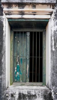 Old wooden windows on old plaster walls There is a steel guard against intrusion.