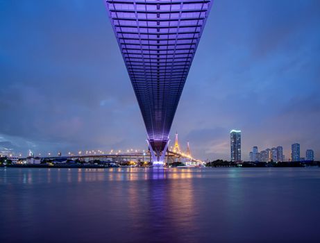 Purple led light under the bridge over the river On a cloudy day in the sky. Bhumibol Bridge, Samut Prakan, Thailand