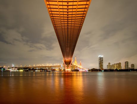 Oreng led light under the bridge over the river On a cloudy day in the sky. Bhumibol Bridge, Samut Prakan, Thailand