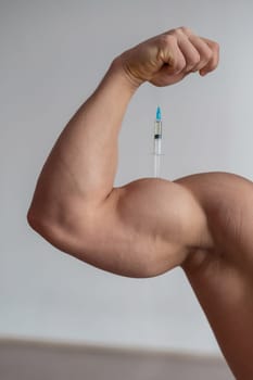 Close-up of male biceps. Unrecognizable male bodybuilder puts himself an injection of testosterone. Faceless athlete takes growth hormone. Vertical