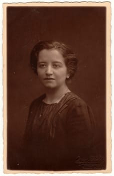 HAMBURG, GERMANY - JANUARY 10, 1920: Vintage photo shows woman -portrait. Retro black and white studio photography with sepia effect. Circa 1920s