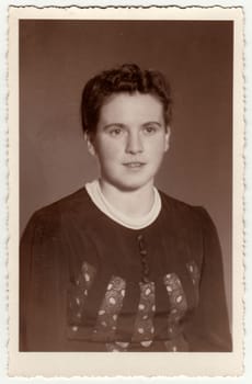 GERMANY - CIRCA 1950s: Vintage photo shows woman with short hair. Retro black and white studio photography with sepia effect. Circa 1950s.
