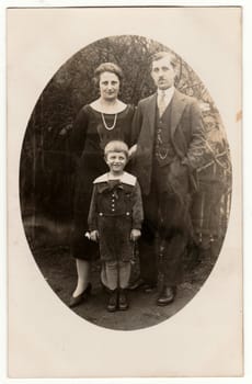 PRAHA - PRAGUE, THE CZECHOSLOVAK REPUBLIC - CIRCA 1920: Vintage photo shows family - father, mother and a small boy. Retro black and white photography of a family. Circa 1920s.