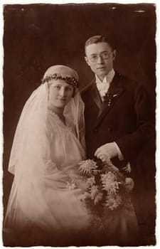 PRAHA - PRAGUE, THE CZECHOSLOVAK REPUBLIC - CIRCA 1930s: Vintage photo shows newlyweds. Groom wears glasses and bride wears long veil. Retro black and white wedding photography. Circa 1930s.