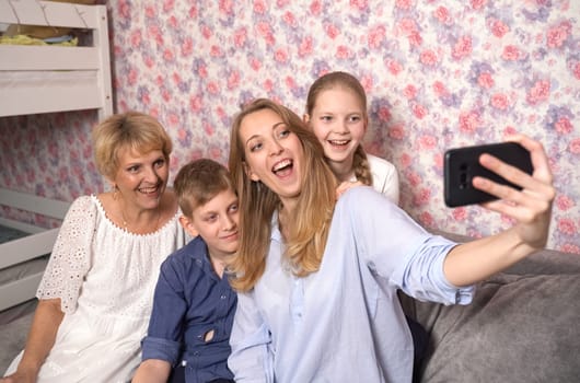 Happy woman takes selfie with kids and grandma.