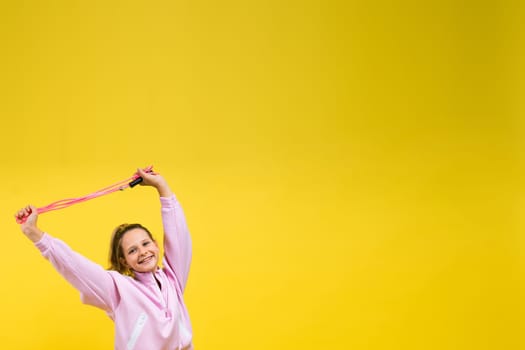 Adorable female child with skipping rope jumping in a studio