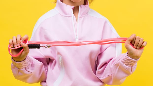 Adorable female child with skipping rope jumping in a studio