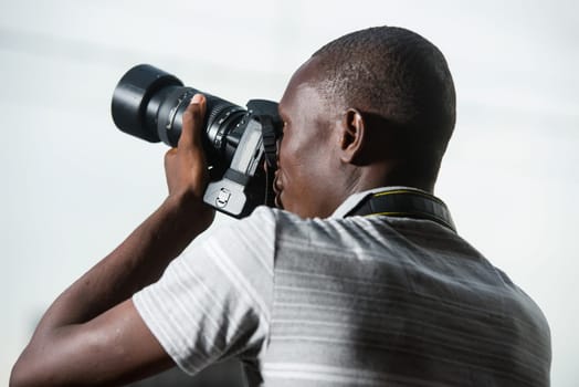 young man outdoors photographing something.