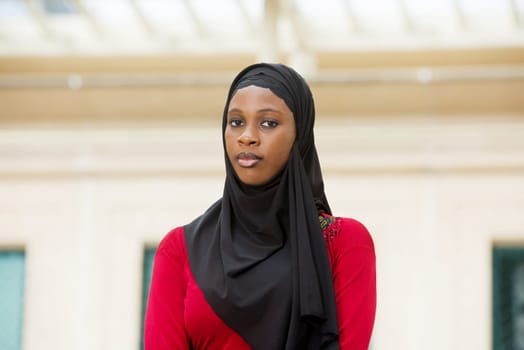 muslim girl standing outdoors and looking at the camera.