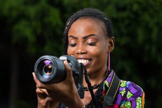 young woman standing up and looking at camera smiling.