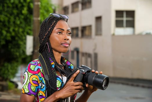 young woman standing right in camera looking at something.