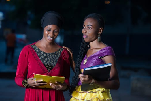 Young female students standing in the street after class talk talking with a smile.