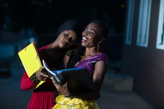 young female students standing outdoors going to check lesson smiling.