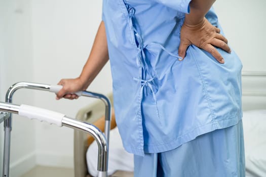 Asian lady patient use walker in hospital to support walking.