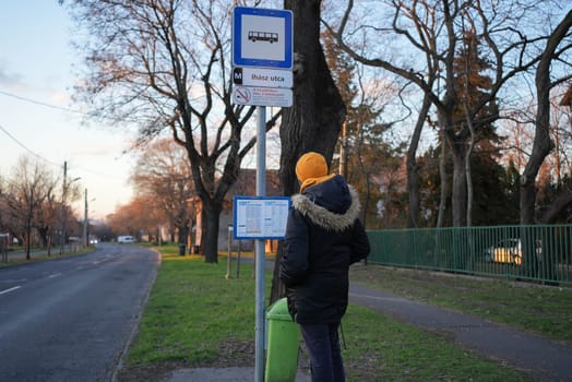 Guy looking at the bus schedule at a suburban area. High quality photo