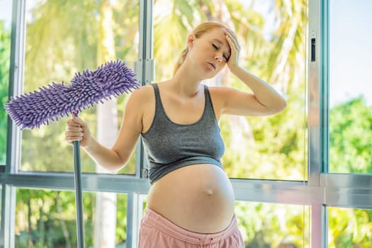 Pregnant woman washes the floor and is tired. Tired pregnant woman having pain in back while she is cleaning her house.