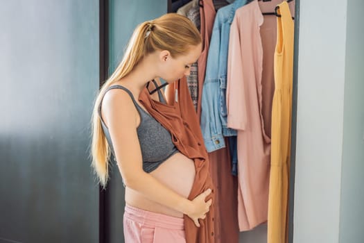 A pregnant woman has nothing to wear. A pregnant woman stands in front of a closet with clothes and does not know what to wear because the clothes do not fit on her.