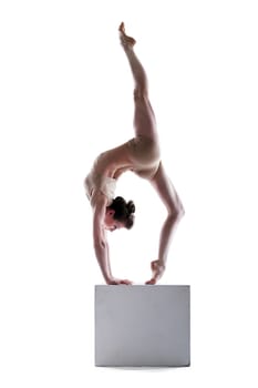 Slim woman balancing on cube in studio, isolated over white background