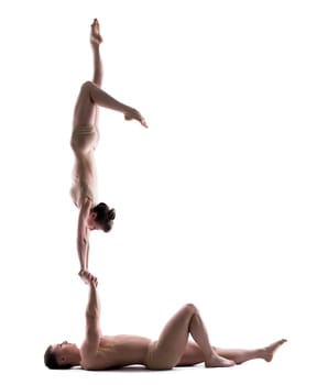 Pair of young acrobats training in studio, isolated on white