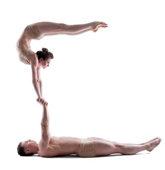 Image of two young acrobats balancing in studio, isolated on white